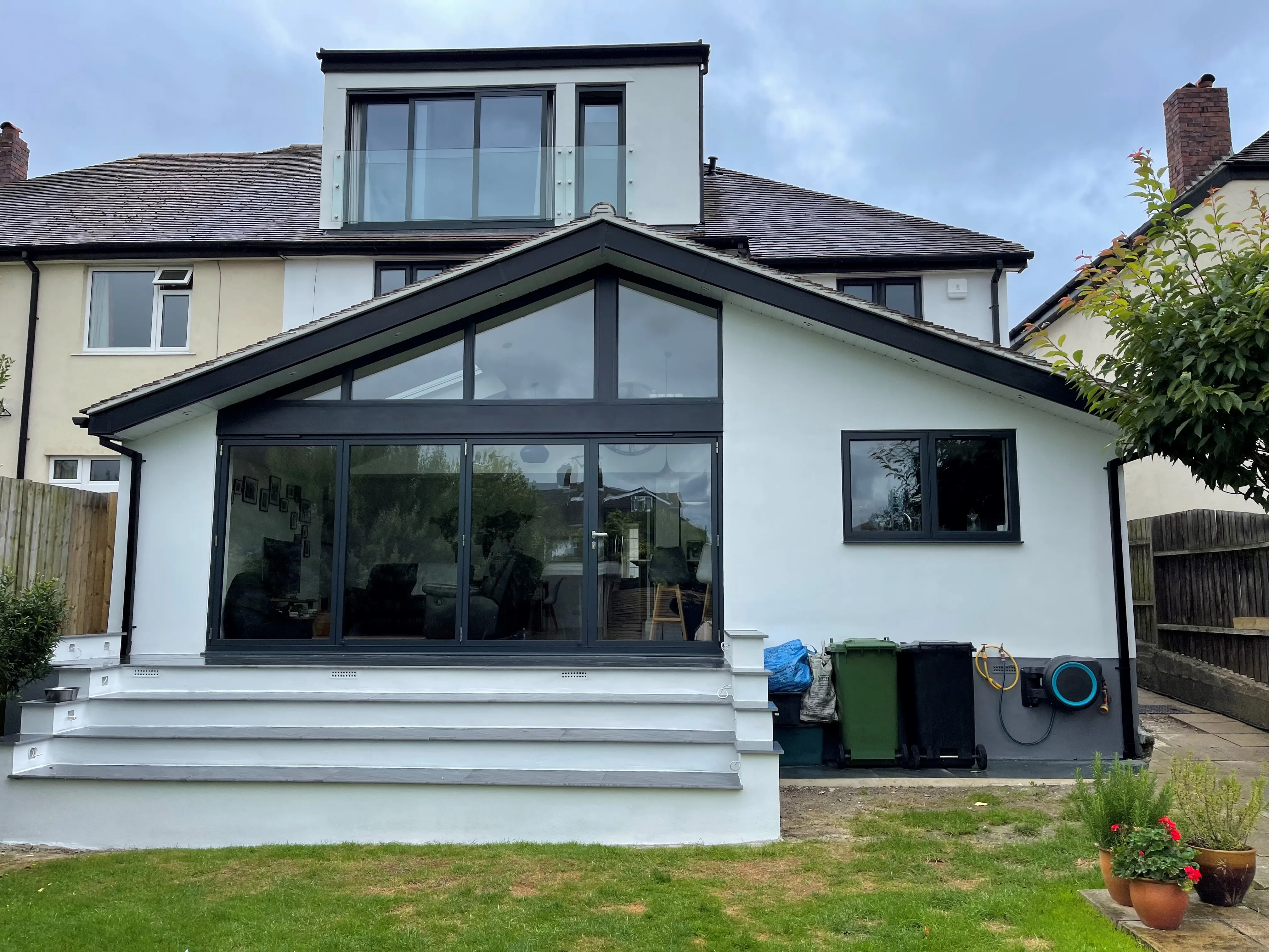 A white house with a black roof and windows.